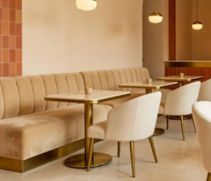 A Bestguidecenter belső tere meleg terrakotta tónusokkal, krémszínű falakkal és brushed brass részletekkel.